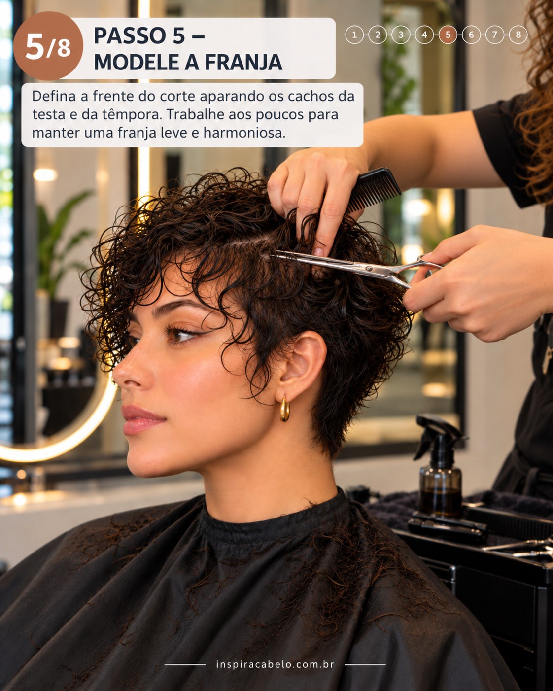 Curly pixie cut com franja leve sendo modelada entre os cachos da testa e têmpora